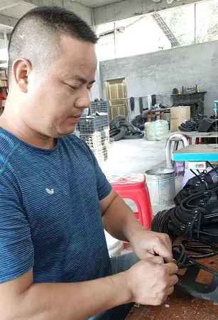 （图为：王瑞铖正在制作胶鞋）.jpg
