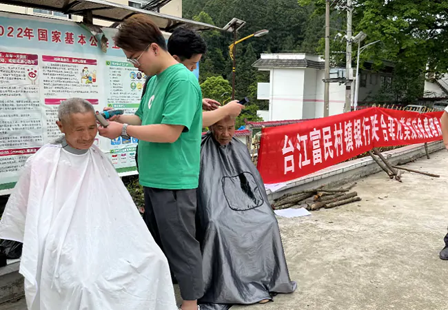(图为:理发师为村民义务理发).png