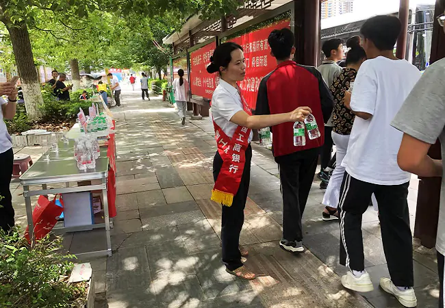 (图为:该行爱心助考志愿者为考生及家长免费提供饮用水).png