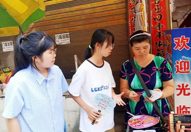 志愿者们向商户宣传反诈知识2.jpg