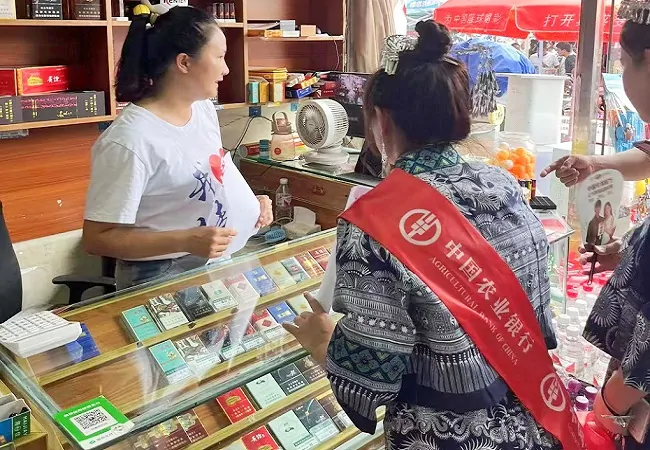 （图为：农业银行榕江县支行工作人员主动上门为商家提供金融服务）.jpg