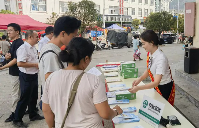(图为:工作人员向群众宣讲金融知识).png