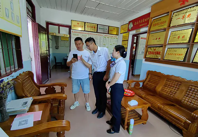 （图为：客户经理到村委开展宣传）.png