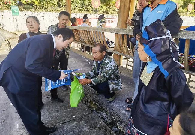 (图为:工作人员进村寨宣传场景).png