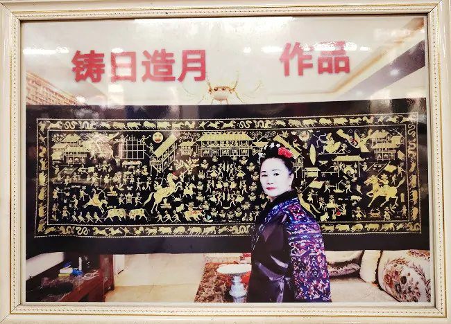 图为：邰英乔和她的苗绣作品.jpg