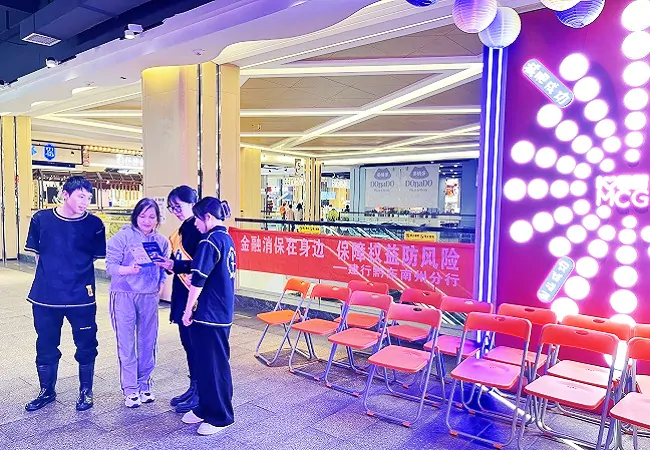 图为：青年志愿者走进凯里国贸购物中心商场向经营者及顾客宣传金融消保知识.jpg