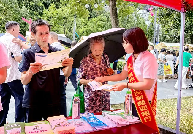 图为：剑河农商银行工作人员向过往群众发放宣传折页.jpg