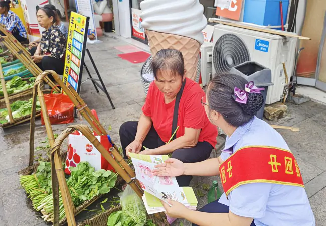 宣传人员在农贸市场宣传金融知识2.png