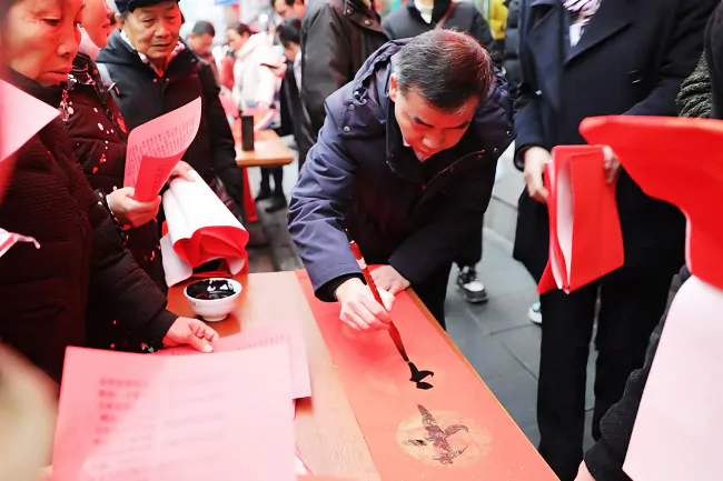书写春联引来群众驻足围观.png
