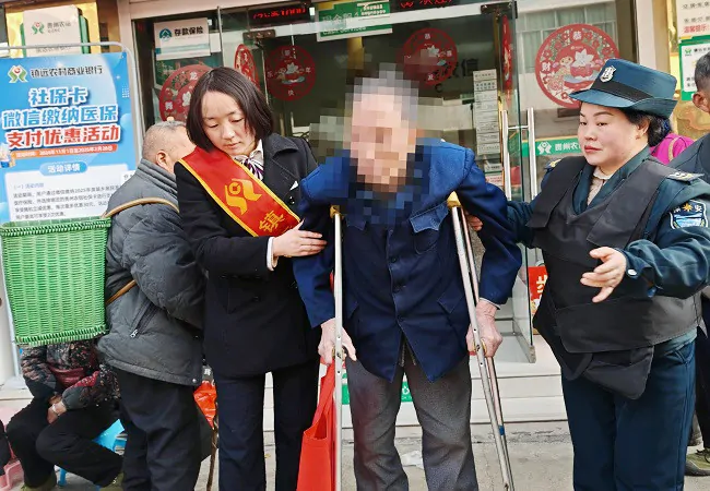 （图为：竹坪支行工作人员搀扶办完业务的老人上车回家）11.jpg