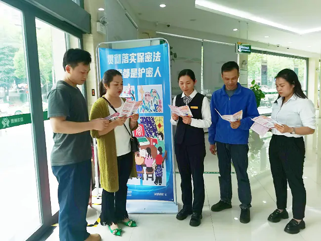 图为:剑河农商银行工作人员向客户普及金融知识.png