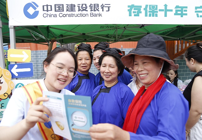 图为：建行工作人员在村超现场为观看足球的观众宣传金融知识11.jpg
