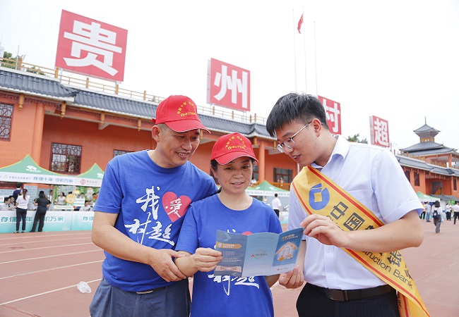 图为：建行工作人员在村超现场为游客讲解存款保险制度11.jpg