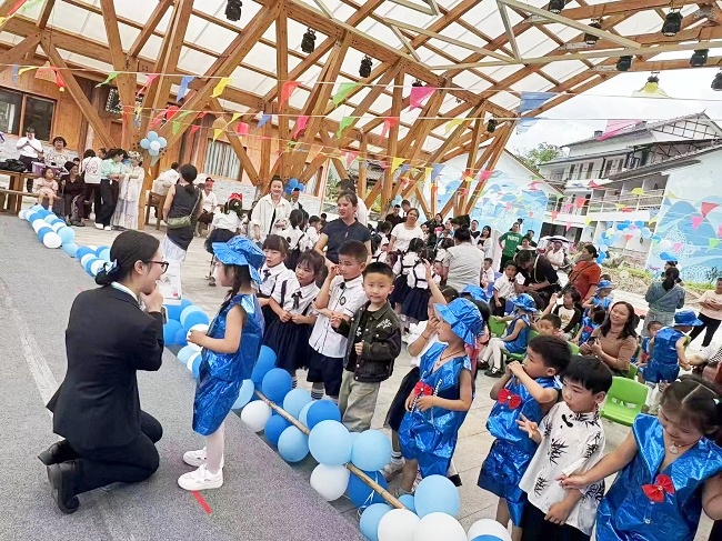 图为：剑河富民村镇银行工作人员向小朋友现场教学金融知识.jpg