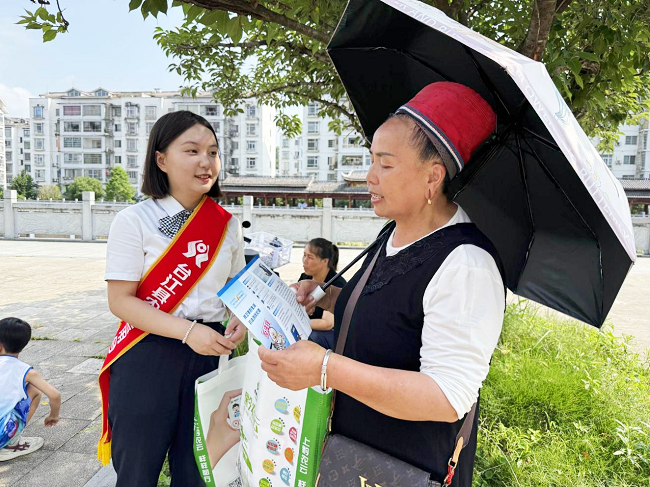 图为：为考生家长宣传金融知识并送上爱心助考物资.png