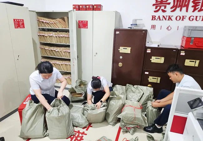图为:贵州银行榕江支行员工正在打包档案紧急转移.png