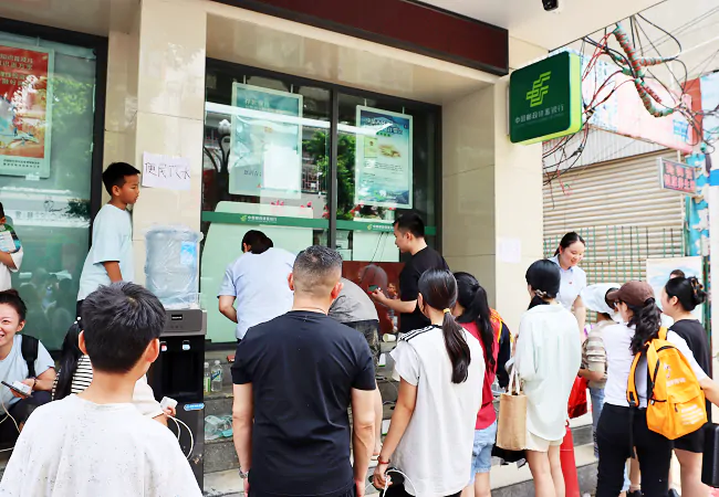 图为:邮储银行榕江县支行为群众提供免费手机充电服务和提供免费饮用水.png