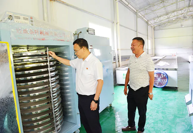 图为：剑河农商银行党委书记袁朝阳实地查看自动化加工车间.png