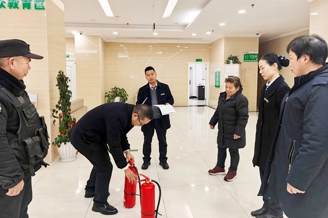 1768985162167300.jpg 图为:小十字支行员工学习灭火器使用方法.jpg