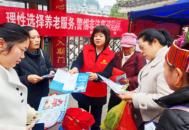 1772007240594622.png 图为:向过往行人发放宣传折页并宣讲防范非法集资知识.png