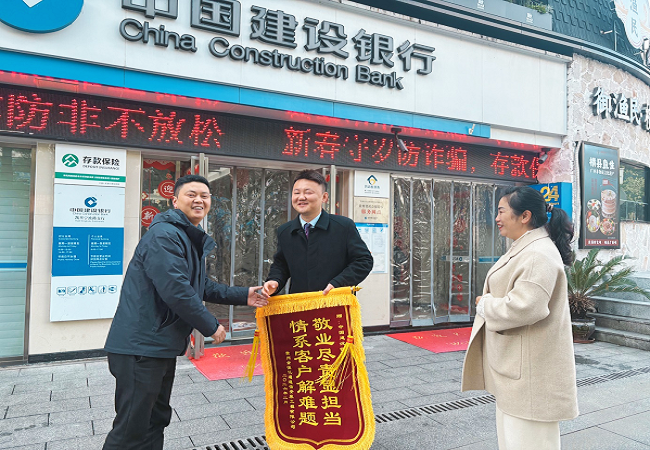 图一：企业负责人陆某握手致谢建设银行凯里宁波路支行工作人员.png