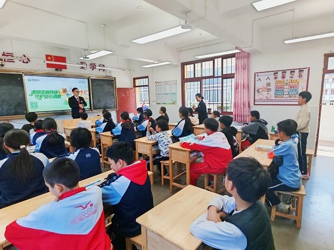 图为：麻江农商银行工作人员走进贤昌小学开展宣传教育.jpg