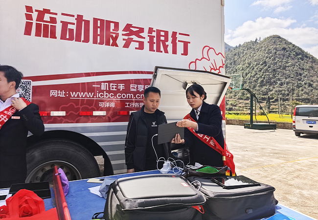 图为：该行通过“流动银行车”为村民开立银行卡2.png