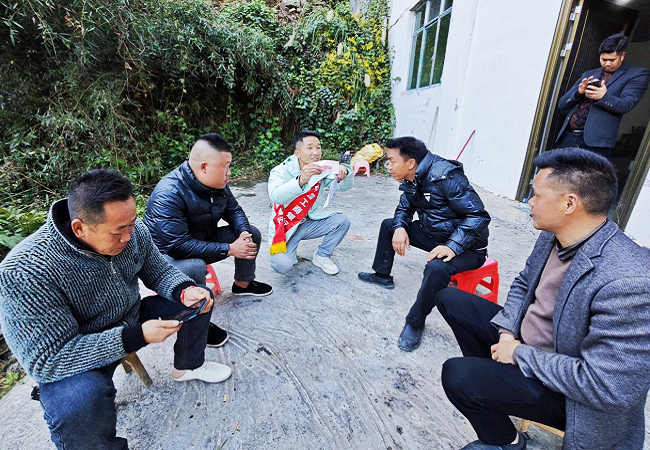 1774602936474328.png 图为:该行驻村干部现场为村民演示假币辨别真伪方法.png