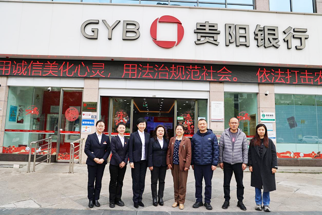 图为：双方与会人员在贵阳银行黔东南分行大楼前合影.png